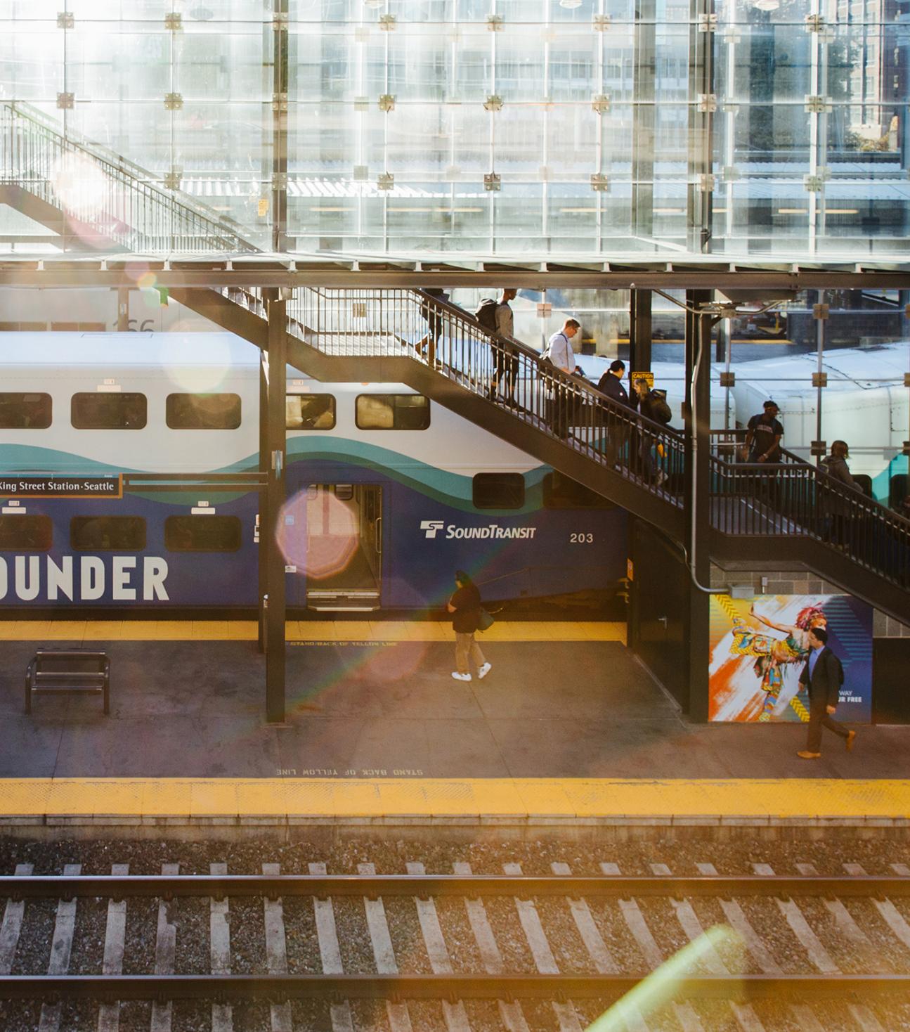 A Sounder Train at King Street Station with passengers walking on the platform.