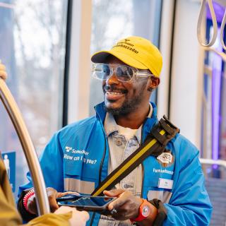 A fare ambassador speaks with a passenger on a Link light rail train.