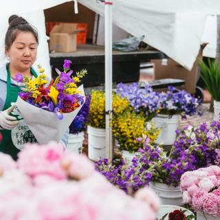 A flower vendor puts together bouquets at the Tacoma Farmers Market