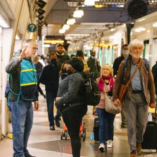 A Sound Transit staff ambassador in a teal vest helps passengers navigate a service disruption