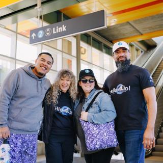Four people wear merchandise from ST Shop at Downtown Redmond Station