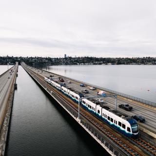 A Link light rail train travels across the I-90 Bridge.
