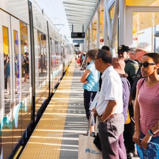 A crowd of people waiting to board a train at a Link station. 
