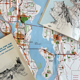 A photo of map of Seattle with transportation related books strewn on top.
