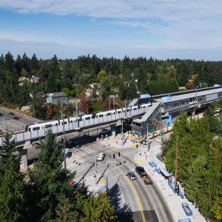 Pinehurst station from above. A Link light rail vehicle is on the tracks at the station. 