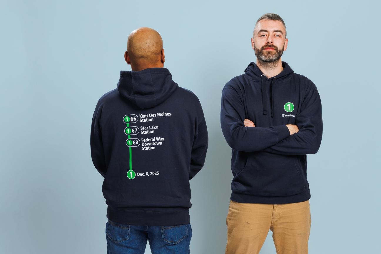 Two people wearing a hooded sweatshirt for the Federal Way Link Extension shop collection.