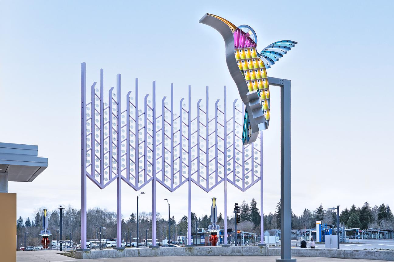City Hummingbird honors the rich history of neon road signs that once lined Highway 99. Its companion, Kitchen Window Curtain, acts as its backdrop, turning the whole plaza into an enormous backyard on a warm Northwest summer afternoon.