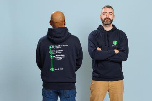Two people wearing a hooded sweatshirt for the Federal Way Link Extension shop collection.