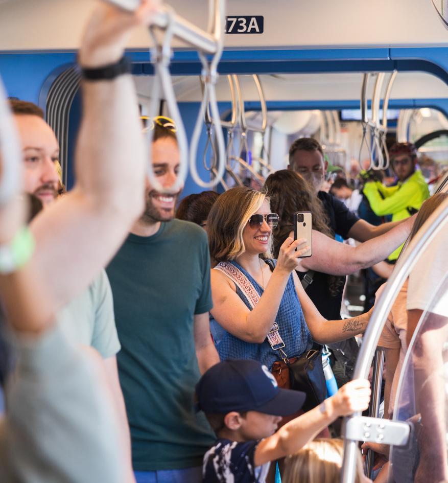 People on light rail train in summer clothes