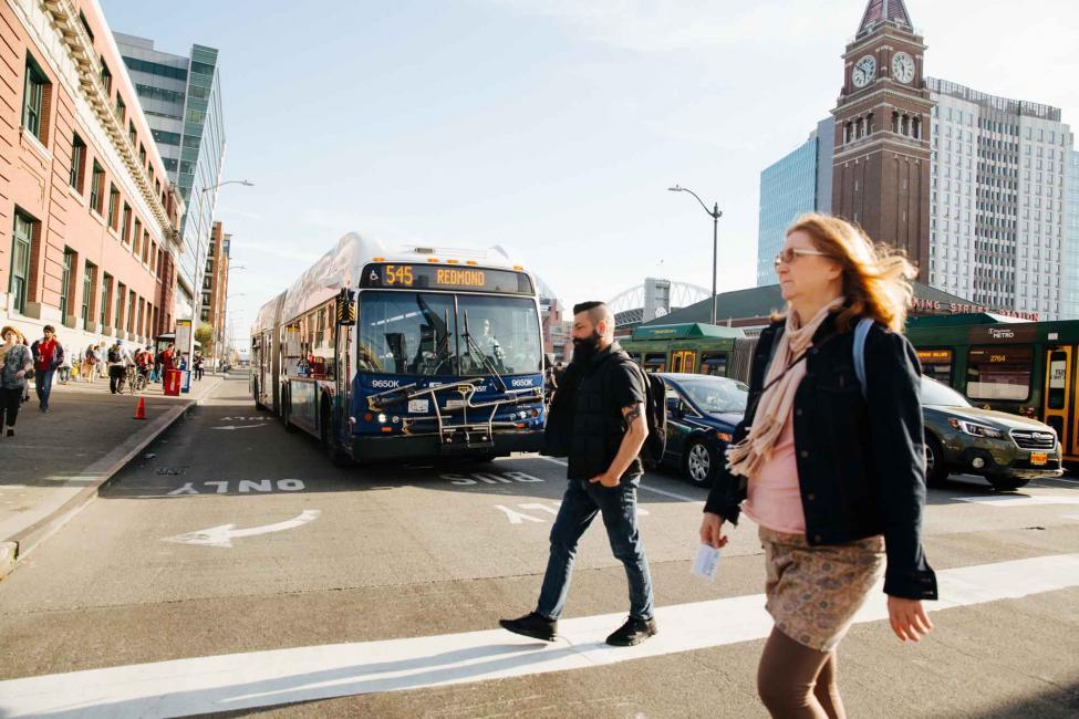 People crossing a street with traffic behind them