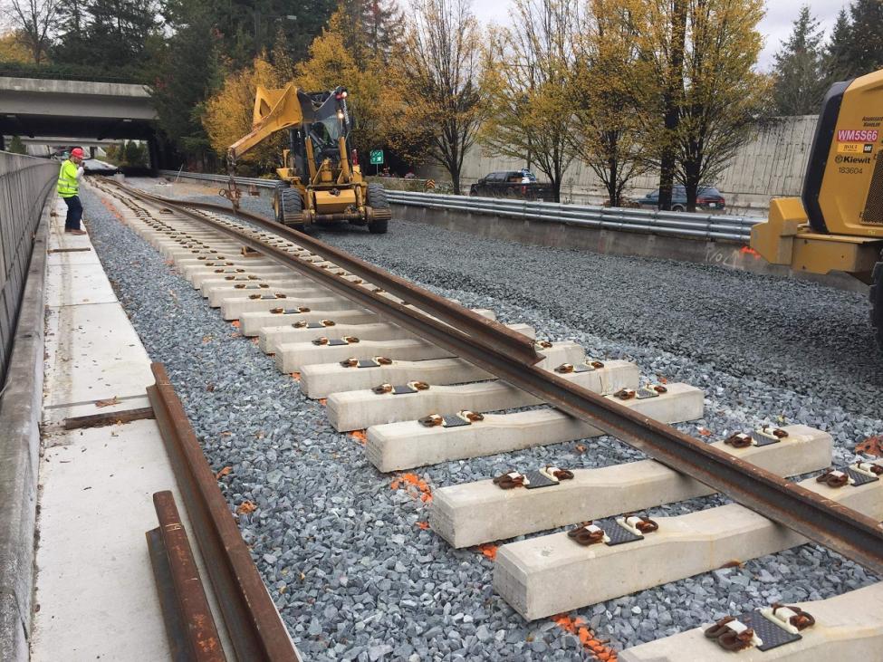 Workers installing rail on Mercer Island as part of the East Link light rail extension