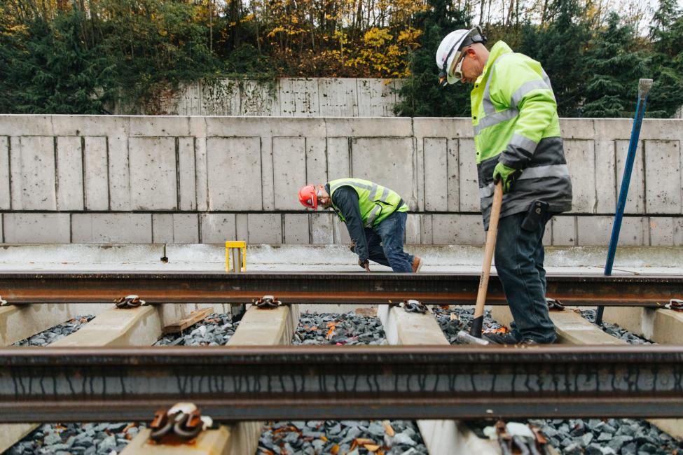 Workers installing rail on Mercer Island as part of the East Link light rail extension