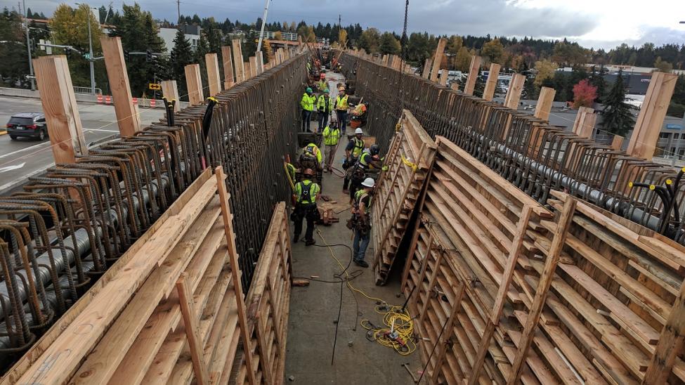 Crews busy inside the bridge over I-405 placing wood forms against the rebar cages waiting to be filled with concrete.