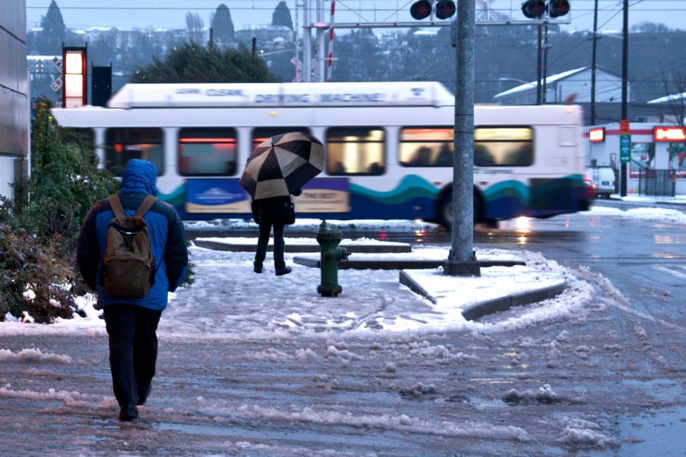 Passengers walk to a Sound Transit bus in winter weather.
