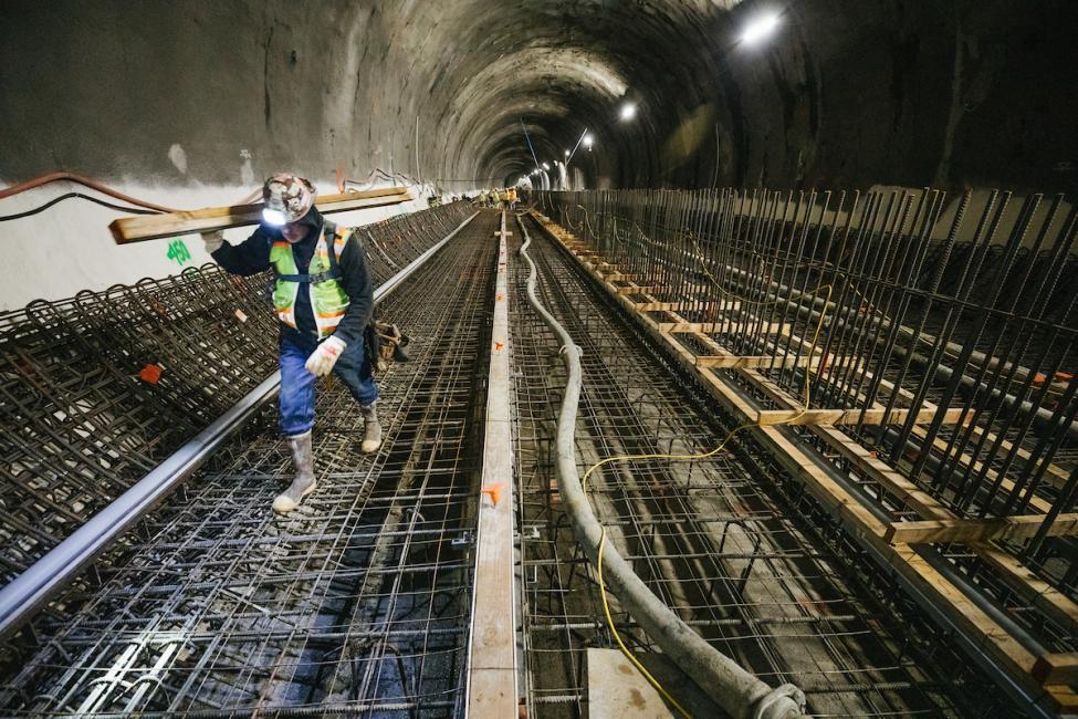 A worker carries steel rebar that will reinforce the concrete track bed in the future East Link light rail tunnel under downtown Bellevue