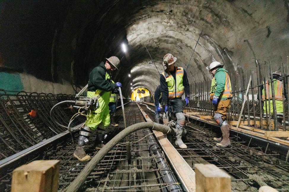 Workers pouring concrete for the future East Link rails in the tunnel under downtown Bellevue.