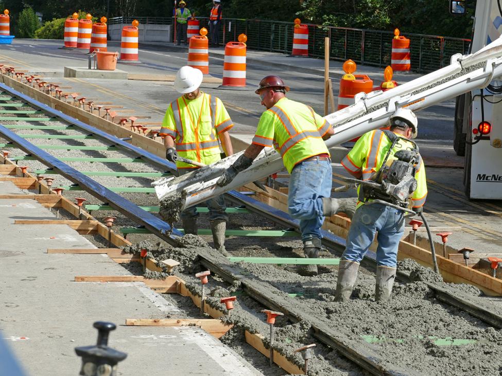 Construction workers guide a chute during concrete pouring