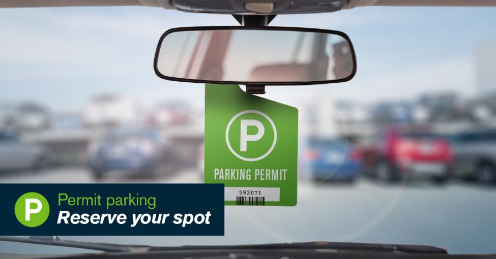 A parking permit hangs from a rear view window in a car.