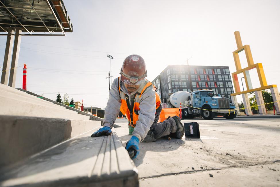 A construction worker touches up cement on the stairs leading to the north entrance of Roosevelt Station.