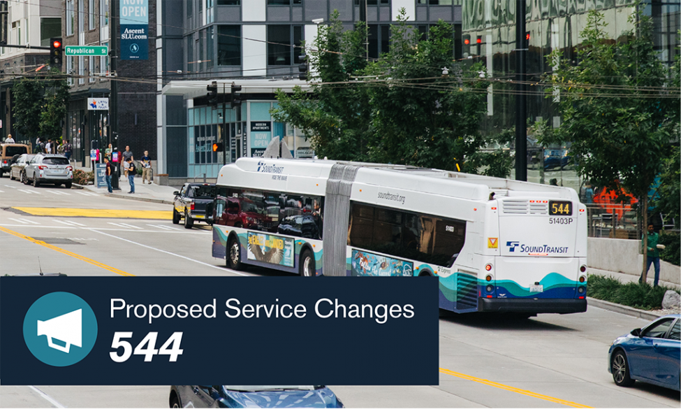 A bus travels through downtown Seattle streets. A banner reads "Proposed Service Changes - 544."