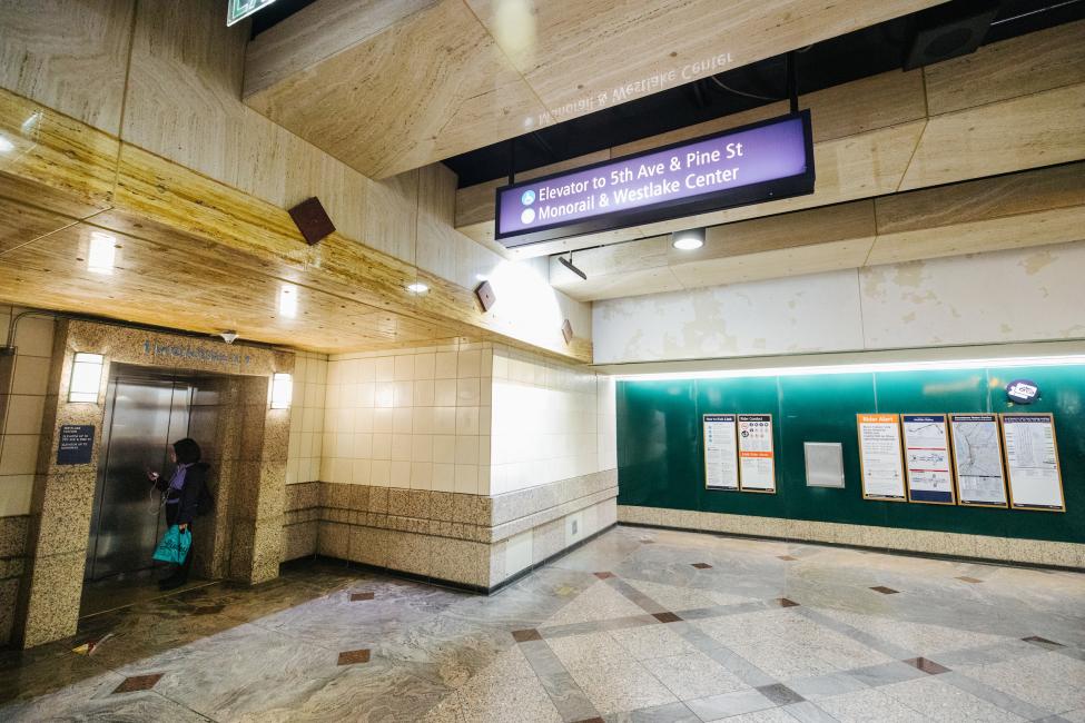 A woman stands by the elevator in the Westlake Station mezzanine that goes to the monorail terminal.