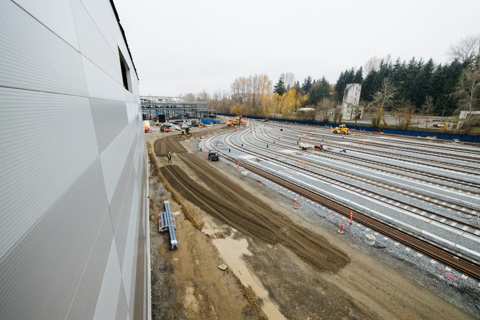 This photo shows the side of the OMF East building, with the rail yard on the right and the Maintenance of Way building in the background.