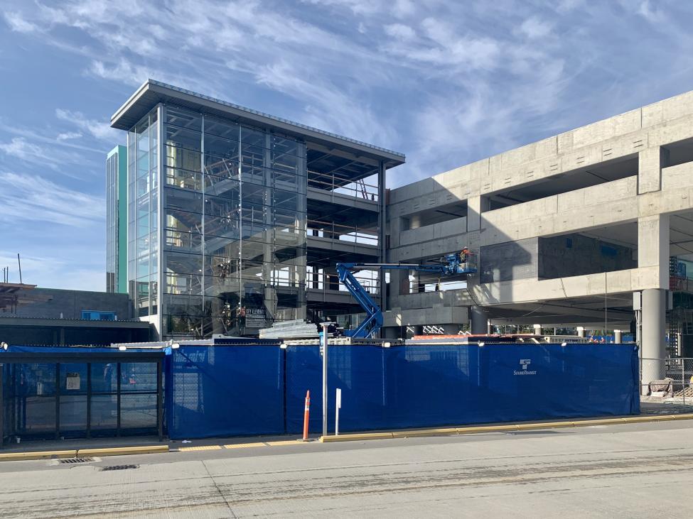 Construction fencing surrounds a new parking garage and future light rail station at Redmond Technology Center.