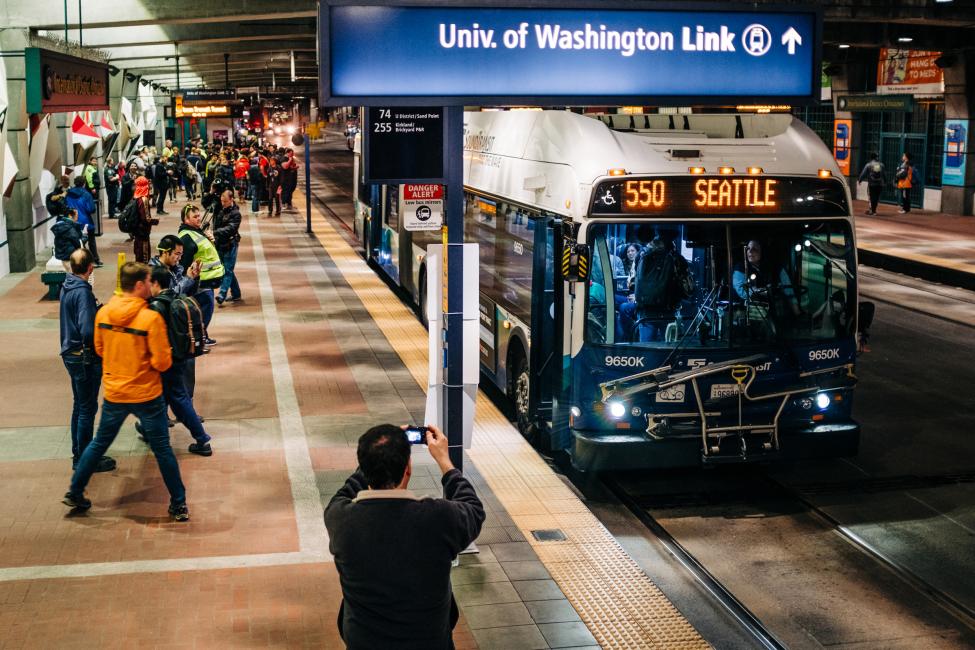 People take photos of the last 550 bus in the downtown Seattle tunnel.