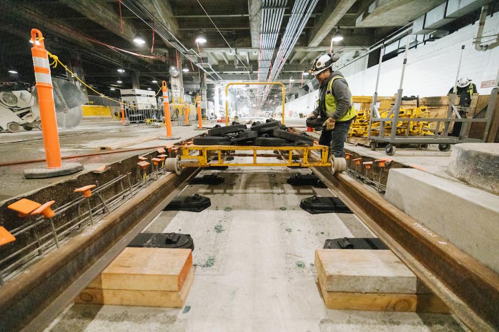 Workers installing new rail connecting East Link with the existing line at Chinatown/International District Station