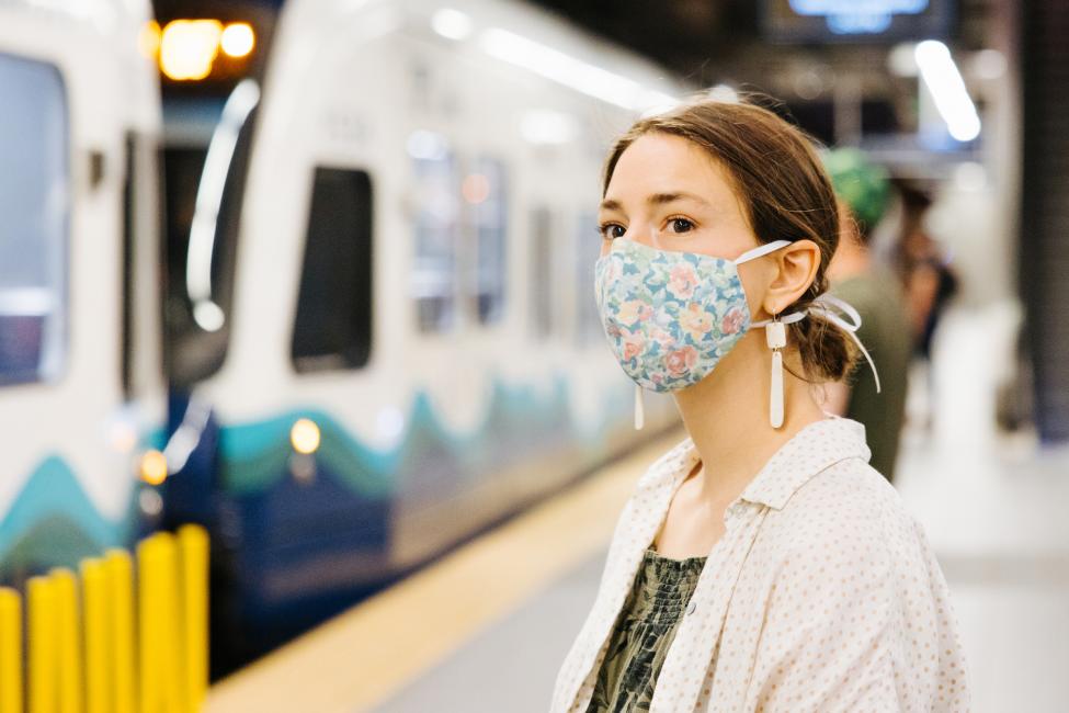 A woman wears a cloth face covering while waiting to board Link light rail at Capitol Hill Station.