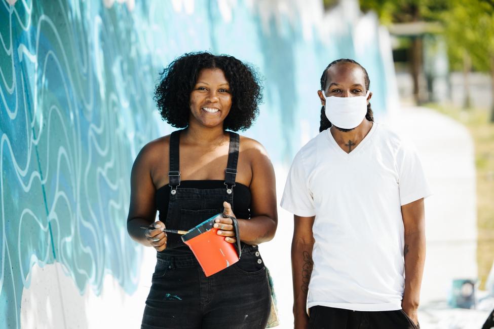 Seattle artists Perri Rhoden and Melvin Freeman in front of their new mural in Seattle's Central District.