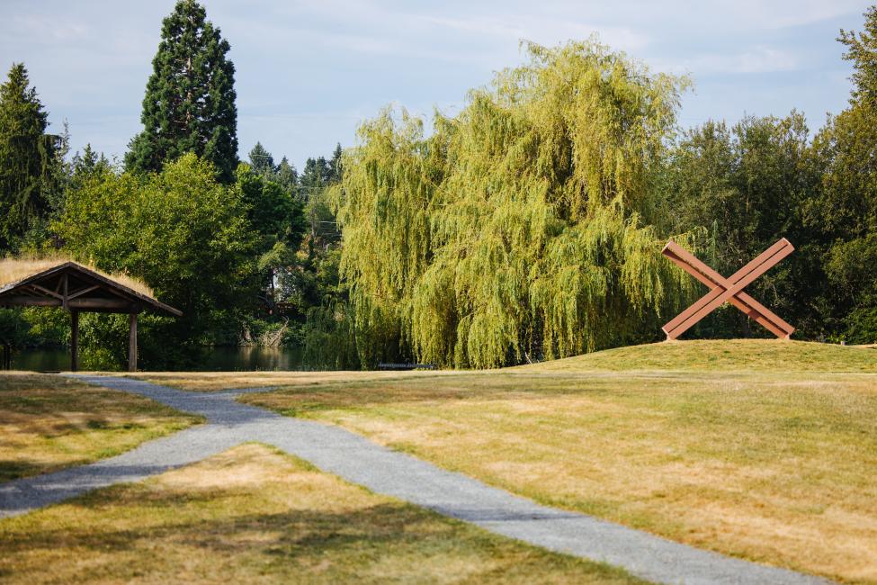 A picnic shelter, walking path and the 'Kiss' sculpture (a painted steel sculpture that looks like an X) are pictured in Ronald Bog Park.