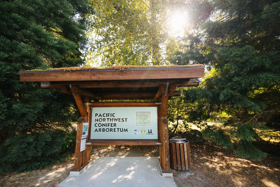 A large sign reads 'Pacific Northwest Conifer Arboretum.'