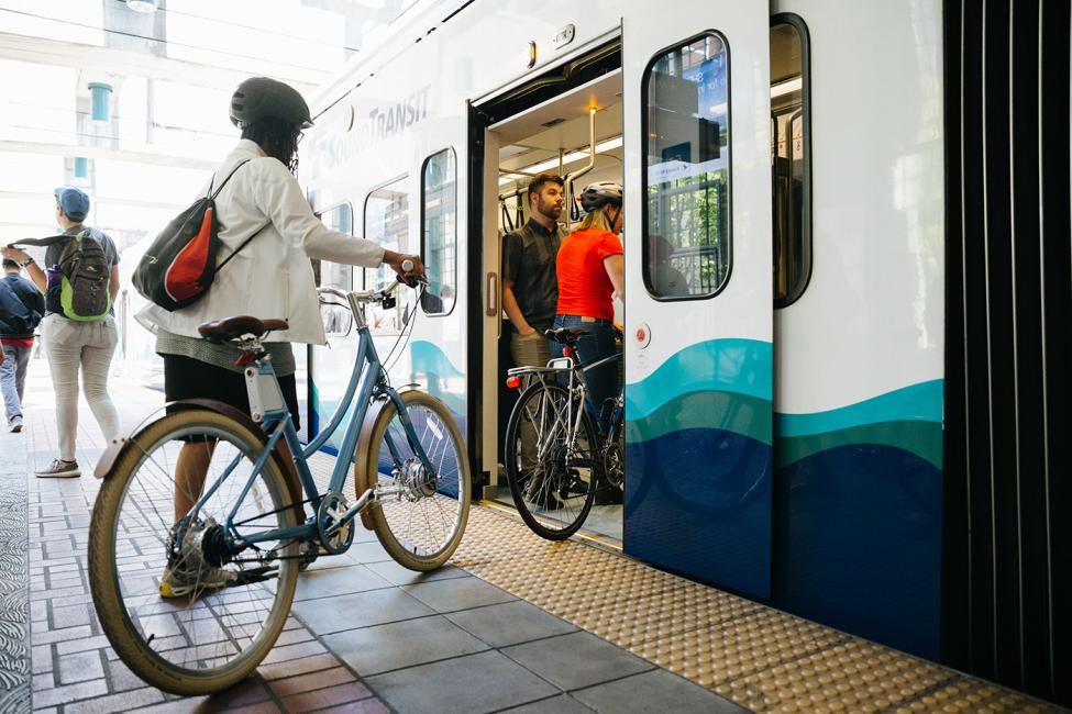 Tacoma Dome Link Extension Open house event header image, photo of bike rider boarding the train