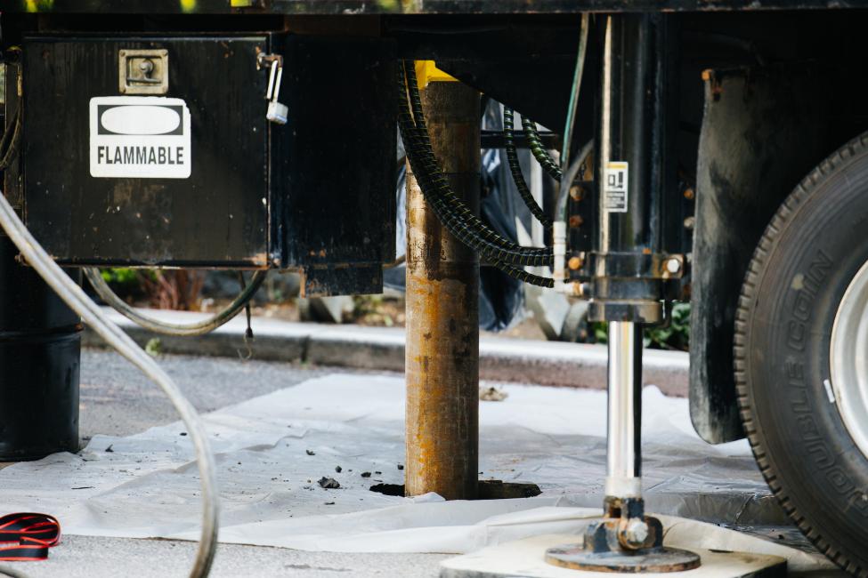 A drilling rig is shown in a hole in the street in downtown Seattle.