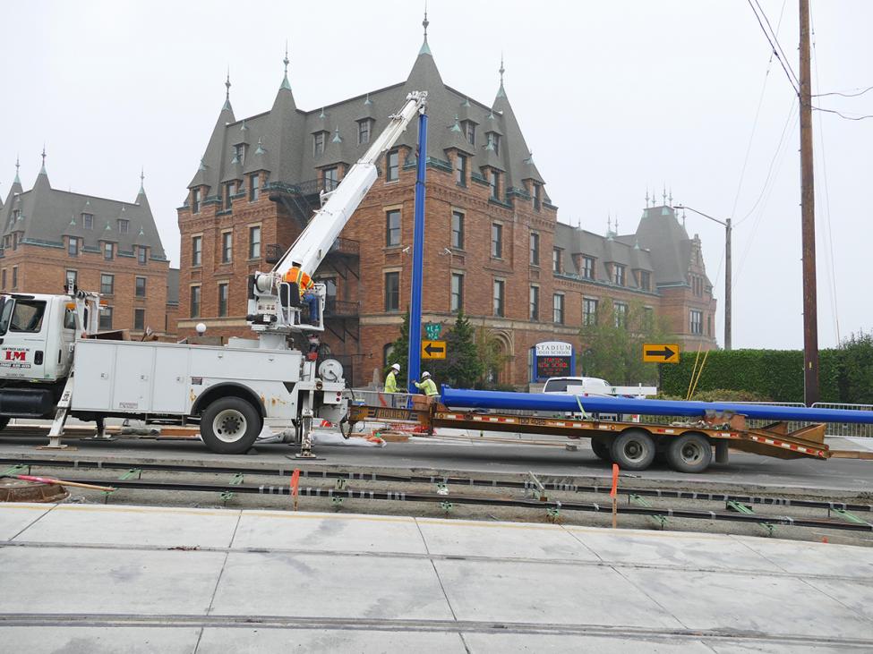 Photo of construction worker Installing a Blue pole at Stadium HS, Hilltop Tacoma Link Extension