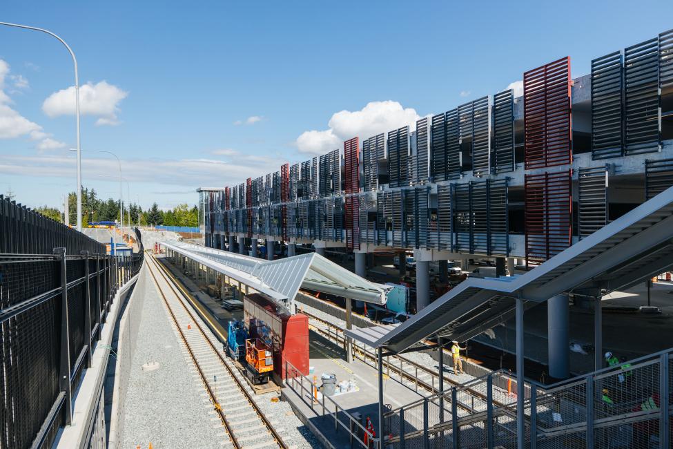 Looking down the stairs at the platform of Redmond Technology Station, with a parking garage on the right.