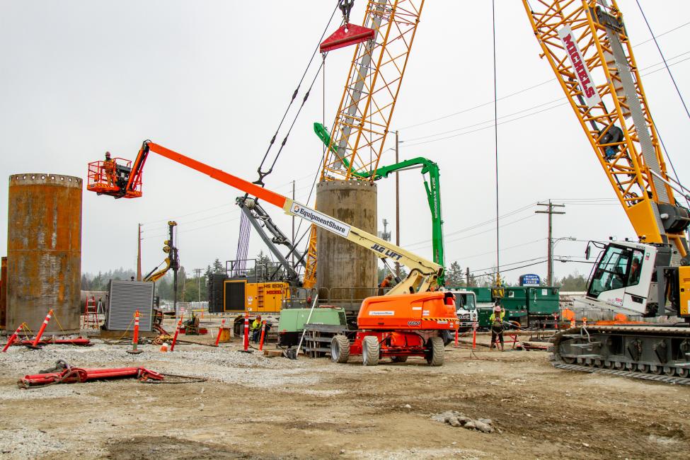 Orange, green and yellow construction equipment is pictured at a light rail construction site near Kent/Des Moines.