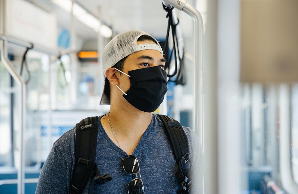 Photo of a rider wearing a mask, project update header image for West Seattle and Ballard Link Extensions