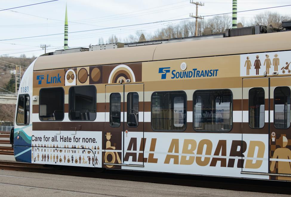 A Link train is wrapped in an advertisement that reads: "Care for all. Hate for none. All aboard." 