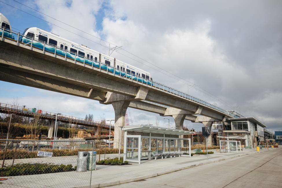 Test trains pass above one of the bus transfer stops at Northgate Station.