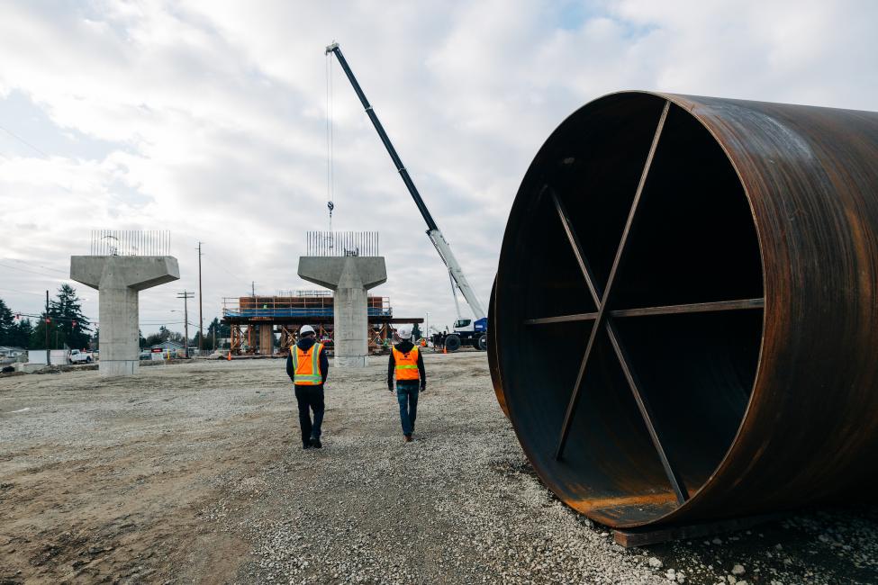 Workers are dwarfed by the support casings used to form the concrete columns at the future Kent/Des Moines Station.