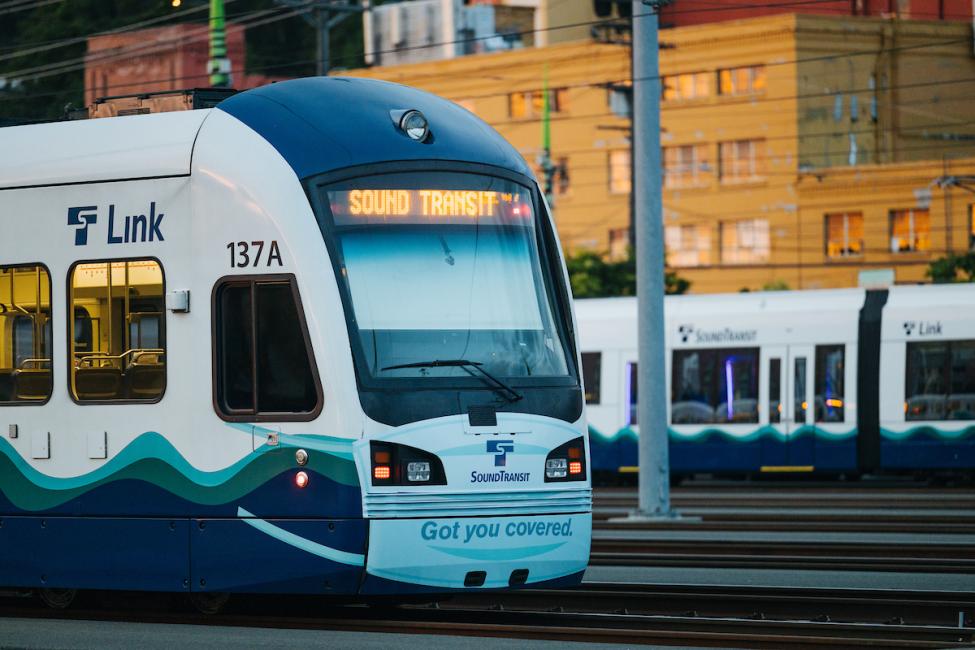 A link light rail train with a mask decal on the front.