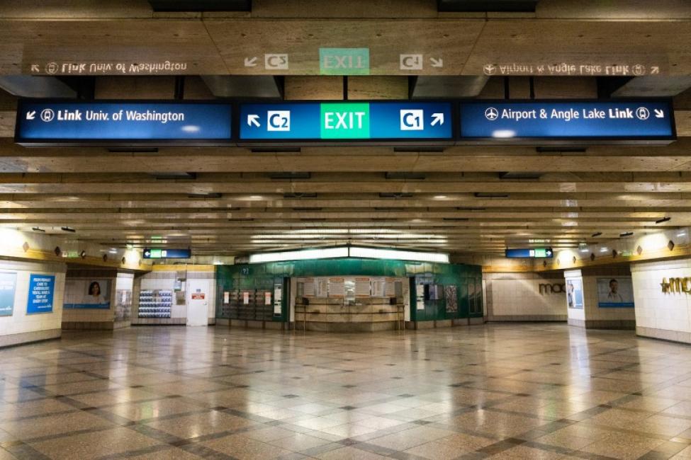 An image shows overhead signs pointing to the exits at Westlake Station.