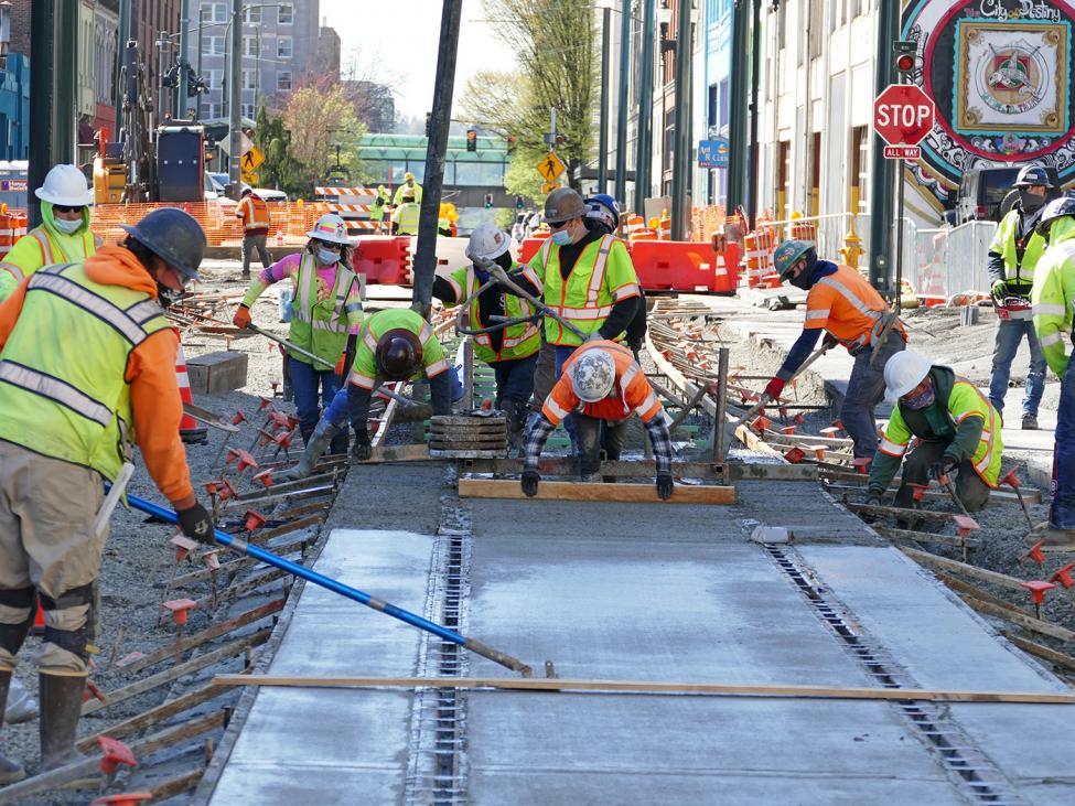 Close-up Photo of construction workers smoothing concrete for rails, Hilltop Tacoma Link Extension