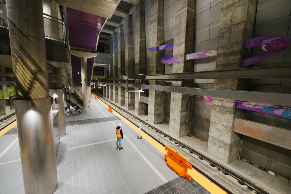 A worker stands on the platform at a nearly complete Roosevelt Station.