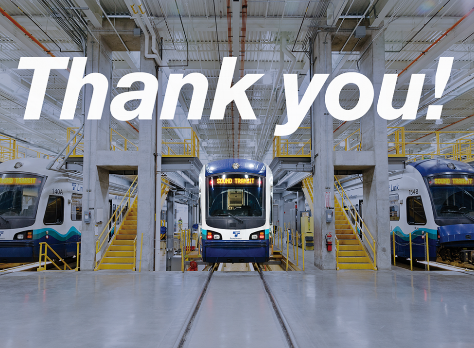 Photo of a link light rail train with the words "Thank you" above the train, Operations and Maintenance Facility South