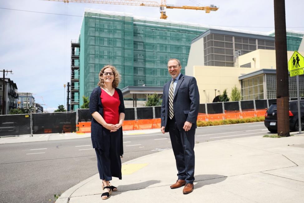 Two people stand in front of Roosevelt Station, which is still under construction. 