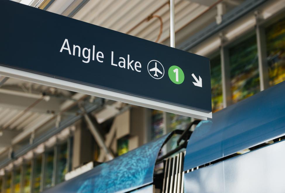A station sign pointing to the 1 Line train to the airport and Angle Lake Station