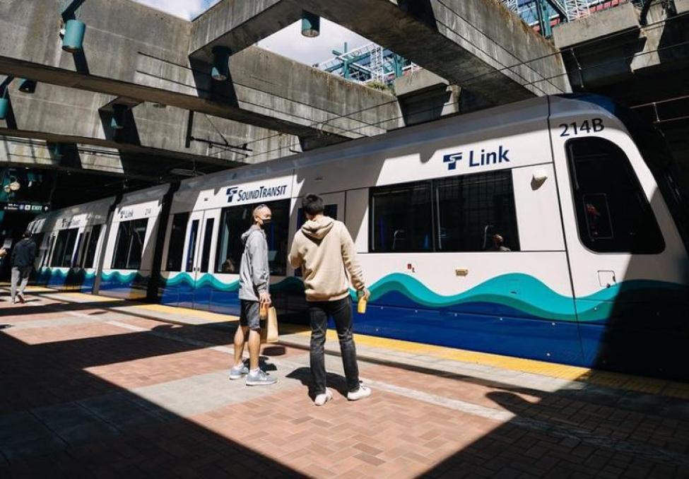 Two people stand in front of a Link train.